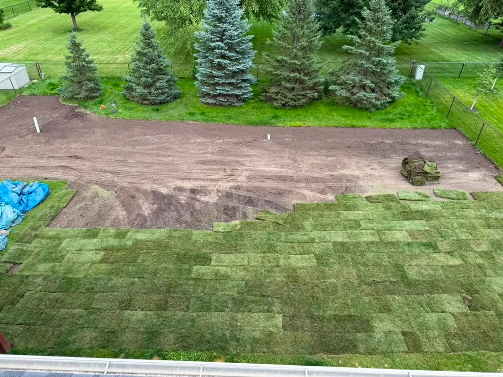 Fresh sod being laid over prepared soil in North Liberty, Iowa